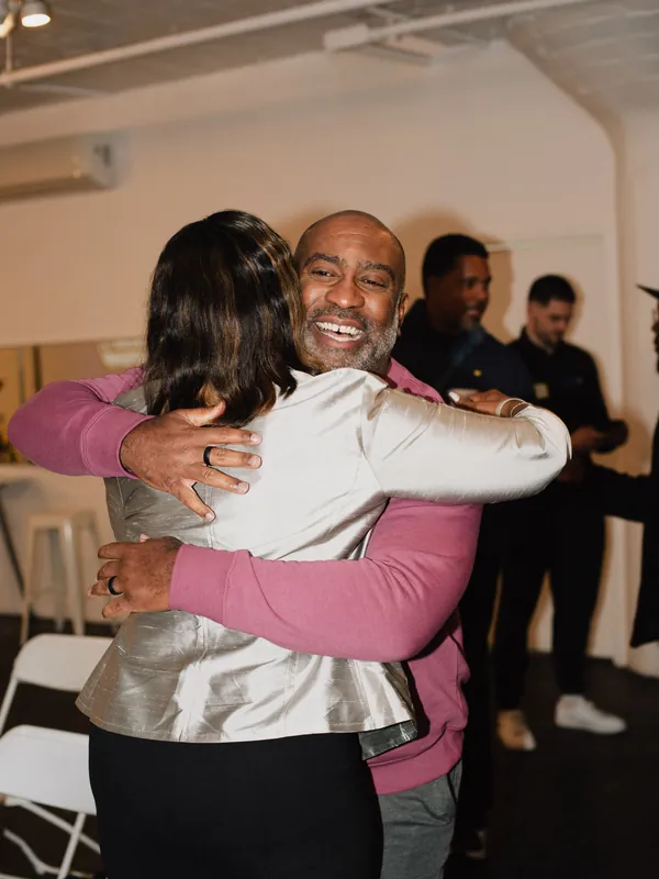 Two guests hugging and laughing at a company event in Los Angeles
